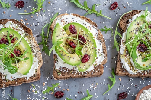 Avocado toast with rye bread cream cheese arugula sliced avocado dried cranberry pumpkin hemp and sesame seeds Vegetarian option Clean eating Overh photo