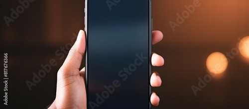 A person holding a smartphone with a display that can be replaced with a different image using a copy space image photo