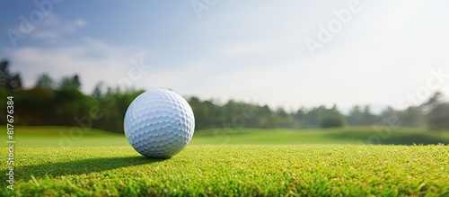A golf ball sits on a tee against the backdrop of the golf course providing ample room for any desired image or text