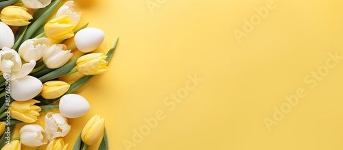 A yellow background with a flat lay composition of tulips and eggs creates an Easter themed copy space image #817680902