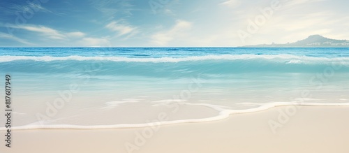 A tropical beach with blurred waves and sand in the foreground Offers plenty of copy space for your image