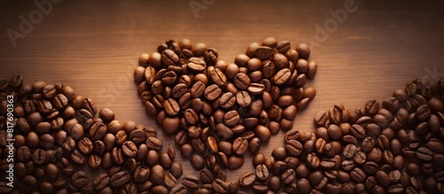 A heart shaped symbol made from coffee beans placed on a background leaving empty space for additional images or text