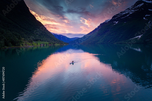Fiery Sunset Aerial: Kayaker Gliding in Full Reflections on Norwegian Fjord photo