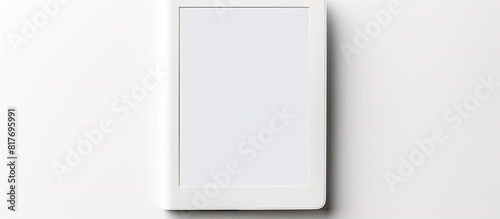 A modern e book reader is placed on a white background creating a flat lay composition with ample room for additional text photo