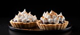 A diagonal placement of two tartlets with meringue featuring a space on the right for text and adorned with chocolate chips. Creative banner. Copyspace image
