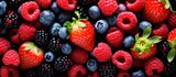 Image of various berries including strawberries blueberries and raspberries set against a backdrop of vibrant colors Cop space image. Creative banner. Copyspace image