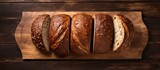 A top down view of three walnut bread loaves arranged neatly on an antique wooden cutting board with ample space for copy