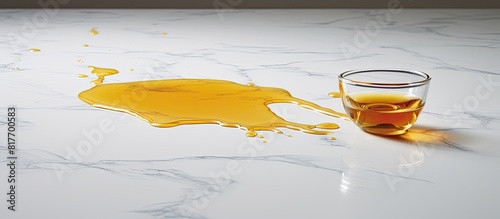 A copy space image featuring cooking oil spilled on a sleek grey marble table leaving room for text photo