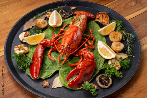 Grilled Lobster with Cheese in black wood plate, Grilled Canadian Lobster on wooden background.