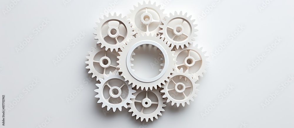 Grey background with a copy space image showcases white gears from a top view Grey background with a copy space image showcases white gears from a top view