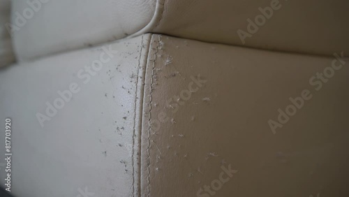 A leather sofa ruined by cat scratches, damaged area. A white and dirty leather sofa. Old leather sofa. Wrinkles in the leather of the sofa photo