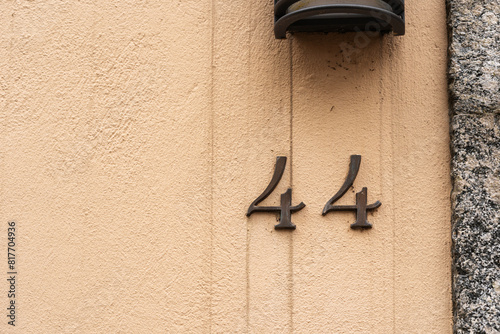 The number 44 is displayed on the side of the building in beautifully crafted handwriting, carved into hardwood with a metal fixture