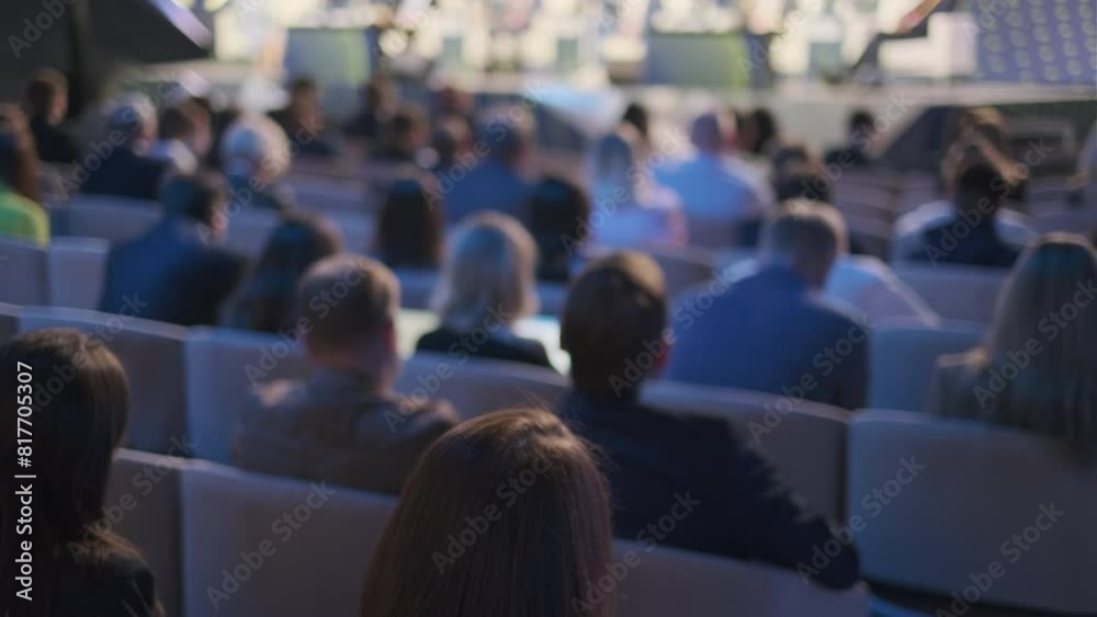 An audience of engaged professionals listens intently at a conference presentation, capturing the essence of business learning and networking in a corporate environment.