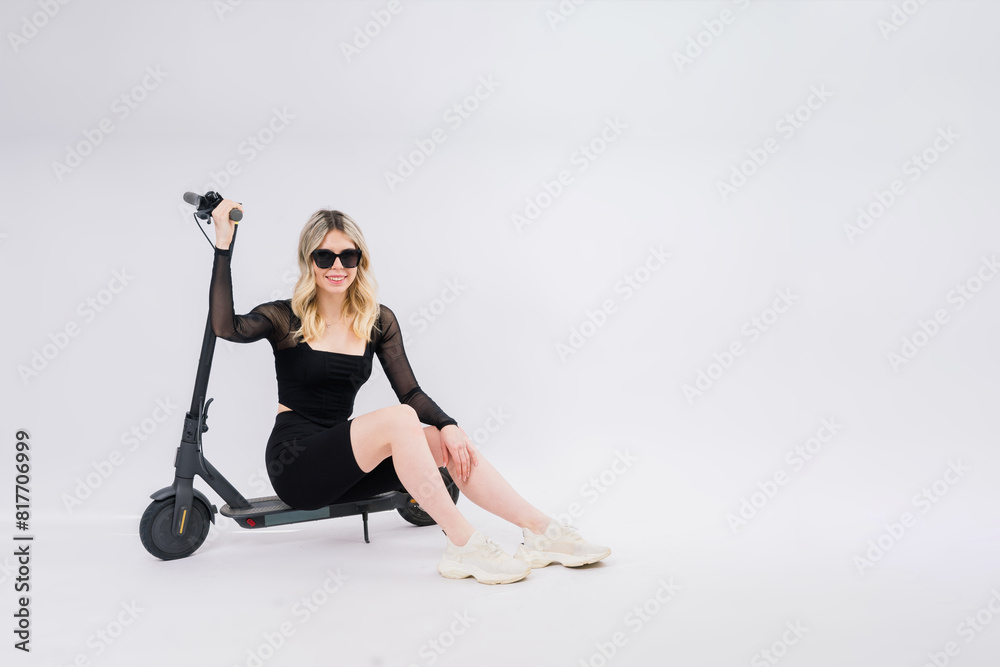 Obraz premium Full body young woman riding electric scooter isolated studio portrait. Lifestyle concept