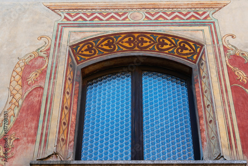 exquisitely decorated window arch featuring vibrant frescoes and blue geometric tiles, showcasing classic European artistry