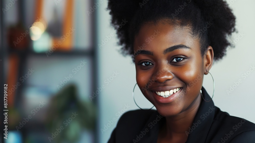 Black Female entrepreneur looking at the camera with a smile. Confident Black Businesswoman Standing in Office. Portrait of a african american, beautiful, young and happy woman in office.