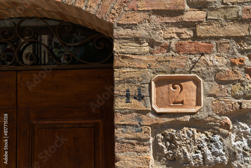 Wooden door with the number 2 is fixture on the brick facade of building