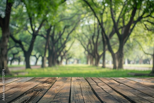 Wooden table top with blurry green background of park trees ideal for product display or montage