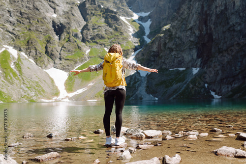 Active woman enjoys the beautiful scenery of the majestic mountains and lake. Travel  adventure. Active life.