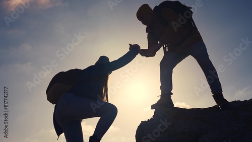 business. teamwork helps hand down business silhouette concept. a group of tourists lend a helping hand, climbing rocks, mountains, lend a helping hand. teamwork people climbers travel climb to top