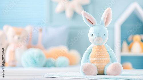 Blue and orange plush bunny in a nursery with soft pastel colors and blurred toys in the background.