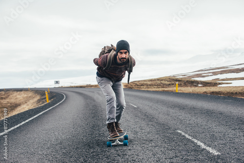 Skater traveling iceland on his longboard. Young man making an adrenaline-filled experience between the lands. photo