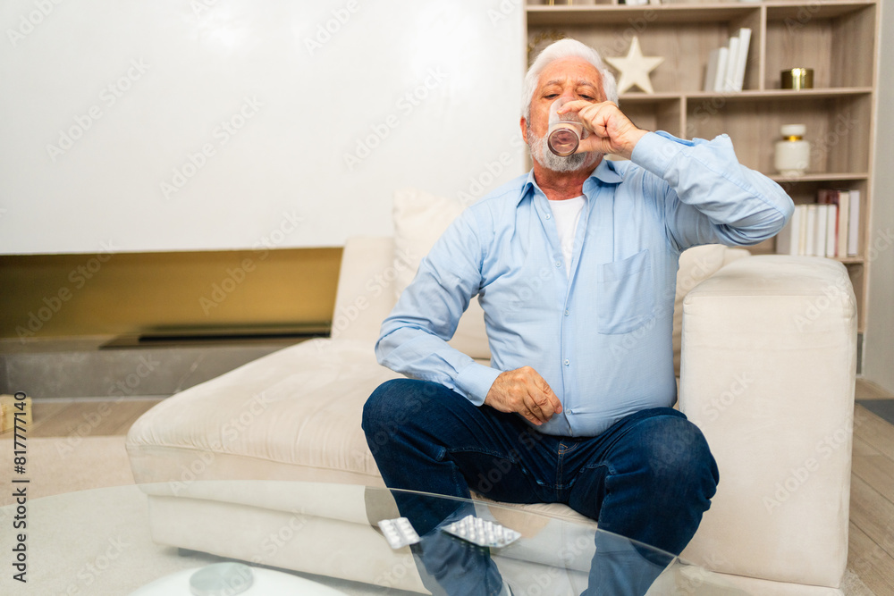Senior man holding glass drinking fresh water at home. Mature old senior thirsty grandfather takes care of his health. Healthcare water balance. Elderly healthy lifestyle