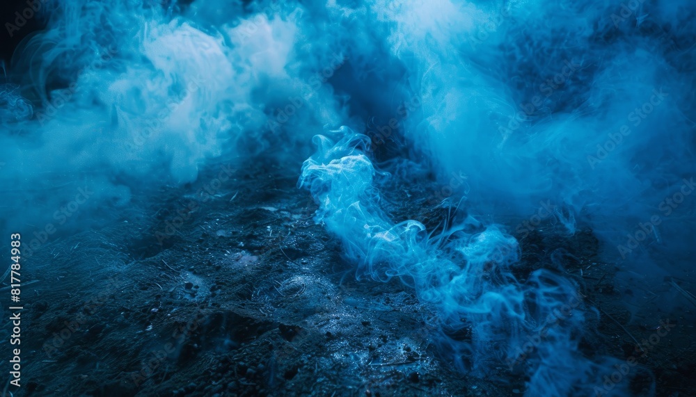 Obraz premium Mystical blue smoke rising from the ground against a dark backdrop, creating a magical and spooky atmosphere, perfect for themes like Halloween and fantasy