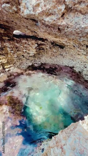 Vertical footage of a natural pool (secret cave) near Pou des Lleo beach in Ibiza island, Spain photo