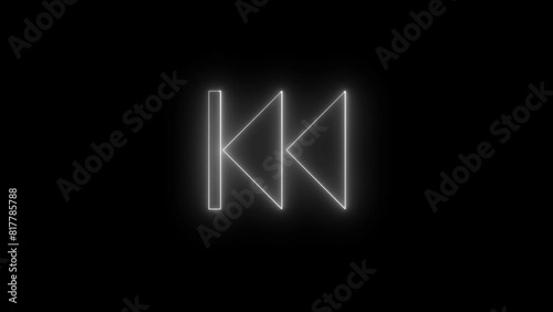 Previous button neon shine fast backward button icon on black background. Music arrow button symbol photo