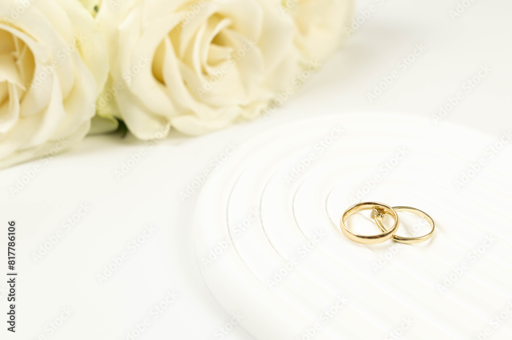 Wedding white roses and gold wedding rings on white background. Wedding composition, white arch tray, podium. Copy space, flat lay. Wedding white roses and gold wedding rings on white background. Wedding composition, white arch tray, podium. Copy space, flat lay.