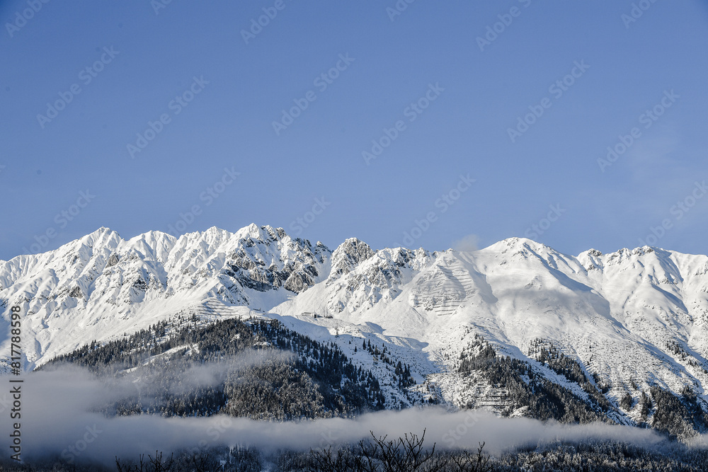 Fototapeta premium The mountains of the Nordkette surround Innsbruck in Tyrol with the summit Hafelekar