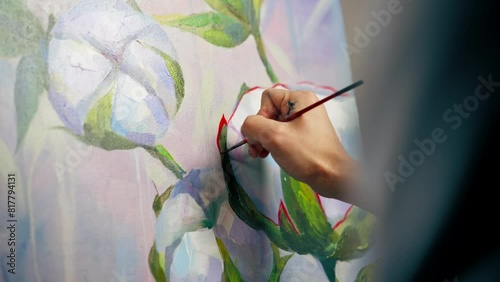 close up in an art studio a painting with flowers the artist sitting the details on the painting with red paint