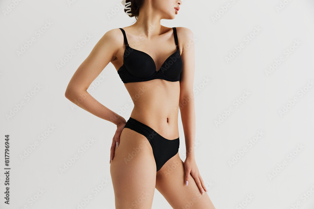 Cropped image of perfect female slim body. Model posing in black underwear isolated on grey studio background. Body positivity. Concept of natural beauty, skin care, sport, wellness, health