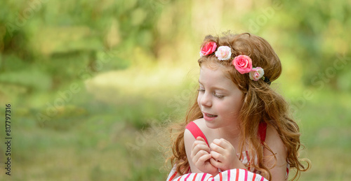Bambina sorridente bionda con fiori tra i capelli, per  comunicazioni sociali, di marketing e di business photo