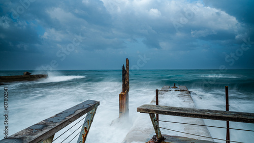 Wooden pier engulfed by the powerful force of high surf and crashing waves