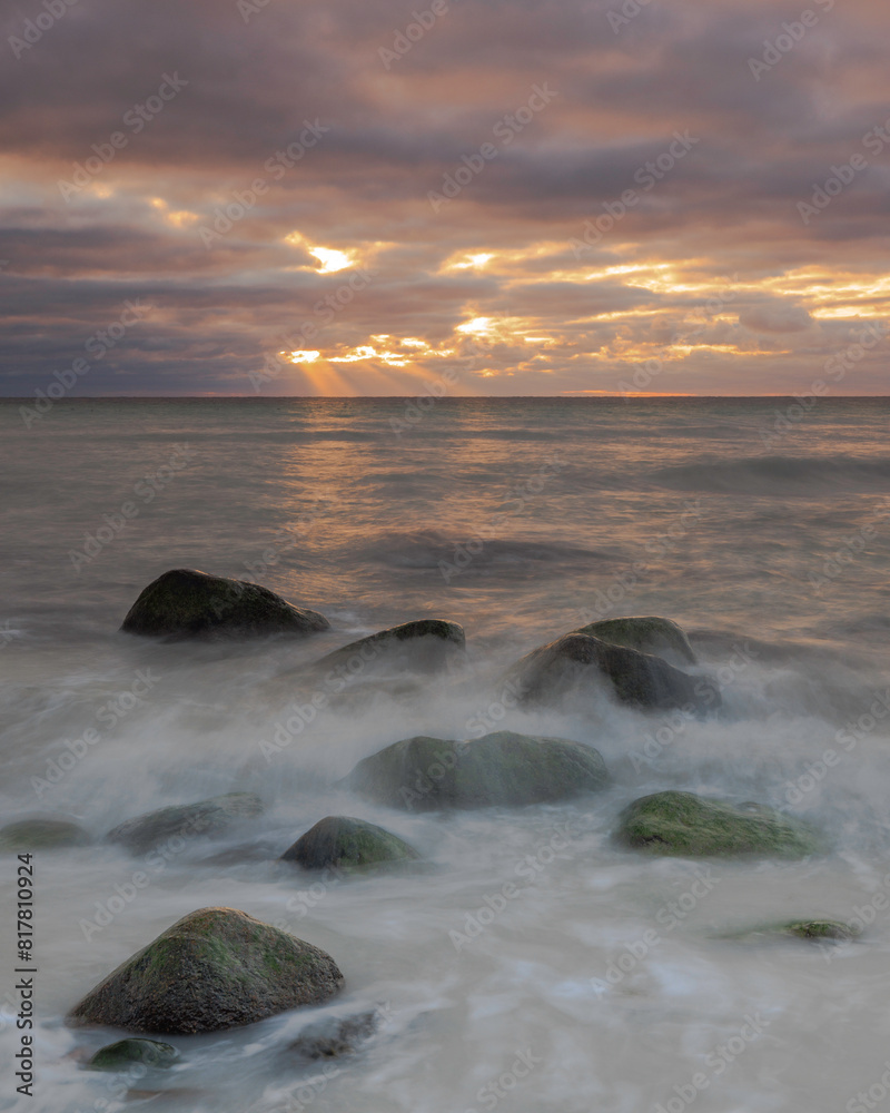 Scenic view of a rocky beach against the sea at sunset Scenic view of a rocky beach against the sea at sunset