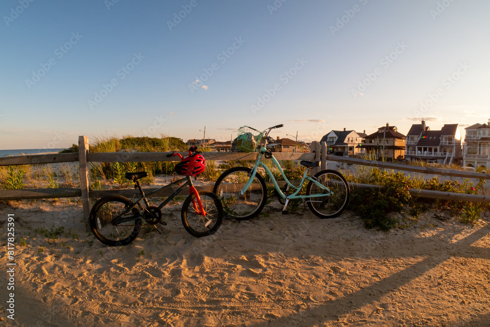 Fototapeta premium two bikes parked on the side of the road in front of a fence
