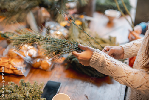 A young girl crafting a Christmas wreath during a decor-making masterclass.