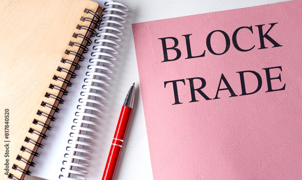 BLOCK TRADE text on pink paper with notebooks BLOCK TRADE text on pink paper with notebooks