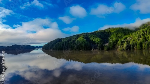 a view of a river with trees and clouds in the sky