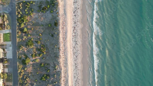 Top-down aerial view of calm waves hitting sand at Aldinga, South Australia, Australia at sunset photo