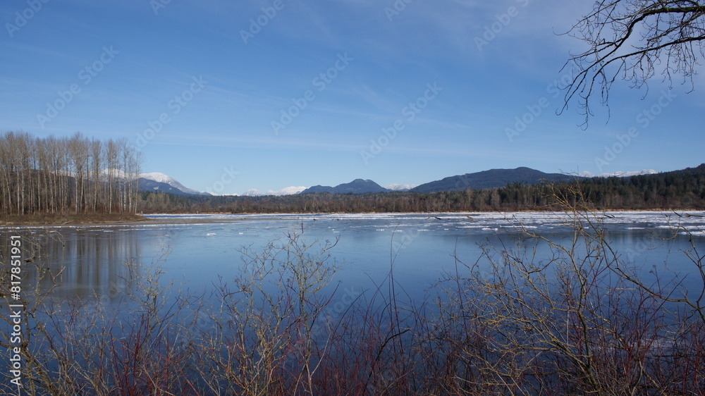 Scenic view of a frozen lake with mountains in the background on a sunny winter day Scenic view of a frozen lake with mountains in the background on a sunny winter day