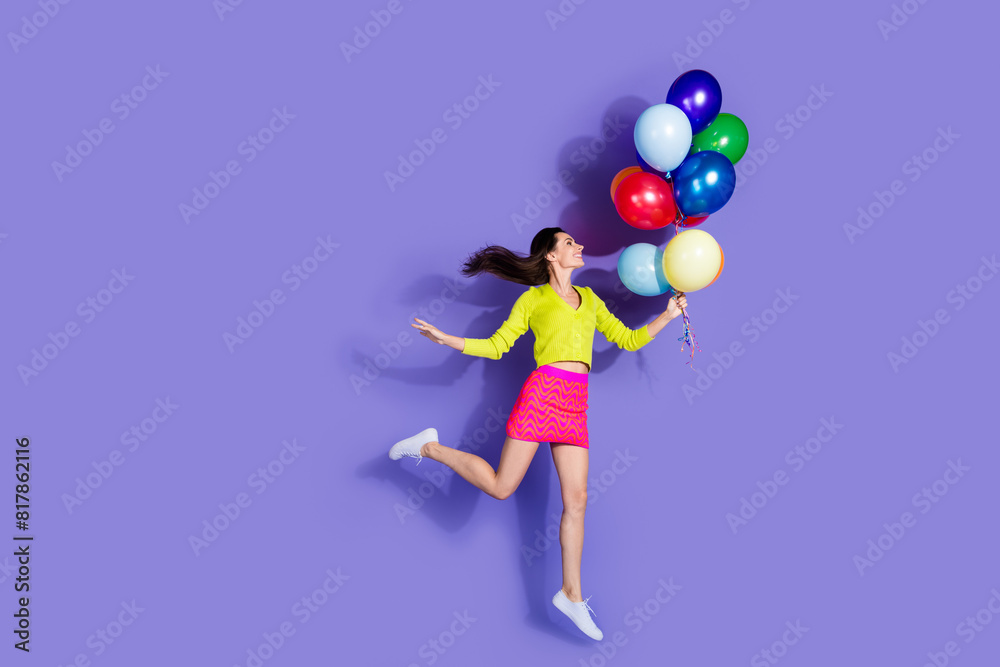 Photo of charming funny lovely cheerful girl wear stylish clothes hold balloons isolated on purple color background Photo of charming funny lovely cheerful girl wear stylish clothes hold balloons isolated on purple color background
