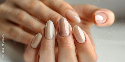 A woman s hands with a light pink and tan manicure