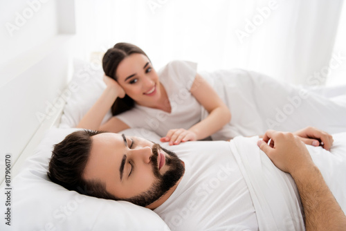 Photo of two people married couple guy sleeping girl touch him in white comfort bed