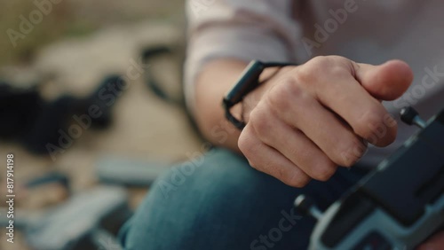 Man's hand attaches joystick to drone controller. Close-up, sunset outdoors. photo