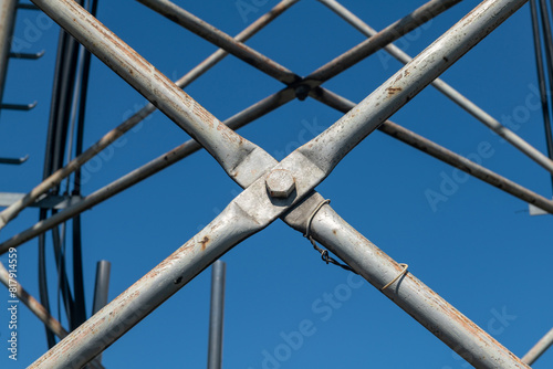 Steel pylon details, reticular structure of a repeater antenna for radio, telephone and communications bands. Stainless steel tie rods and nuts. photo