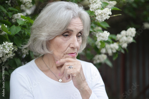 Portrait of senior sad woman in park