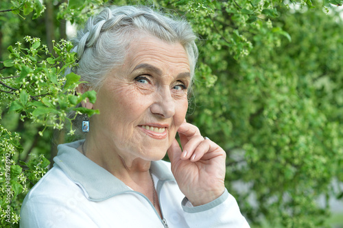 Close-up portrait of happy senior beautiful woman posing in park